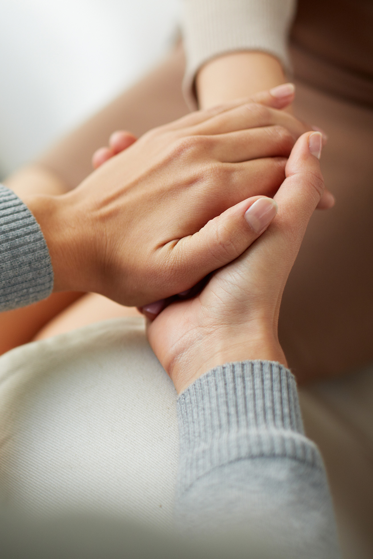 Image of women holding hands in a caring manner