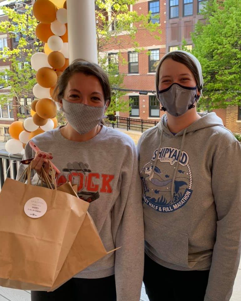 Two girl volunteers bringing a food package to patient in hospital