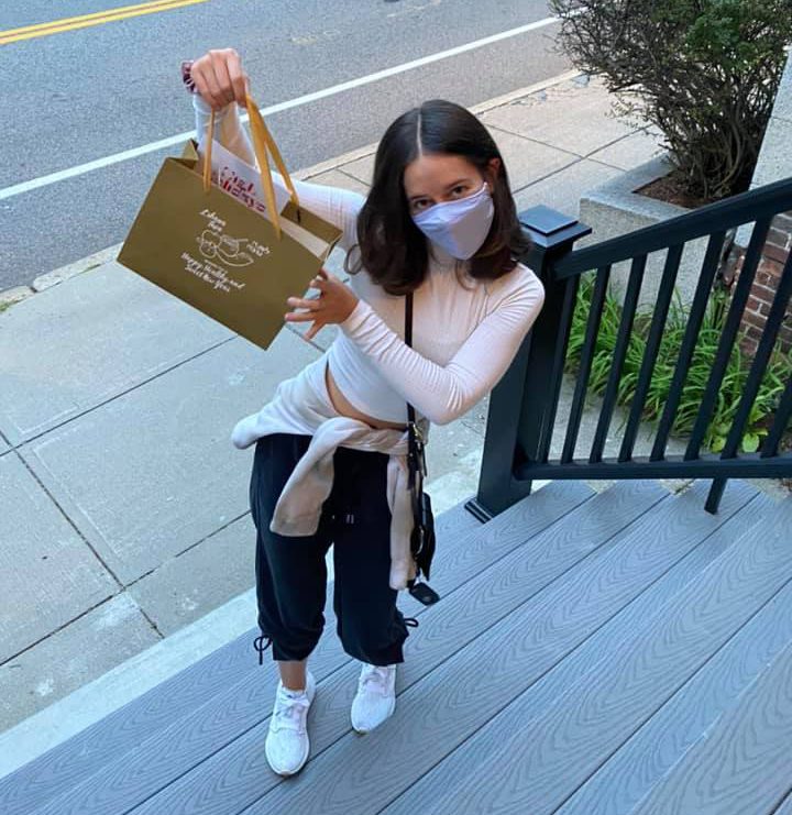 YJP Volunteer Young girl wearing mask and holding a bag of food